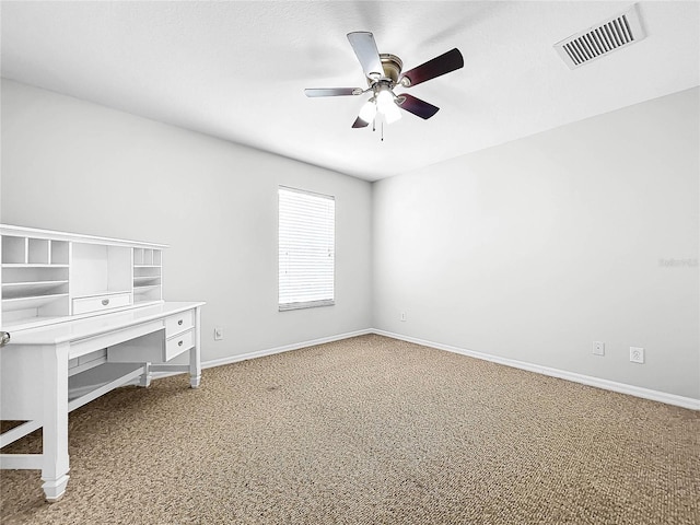 unfurnished office featuring ceiling fan and carpet