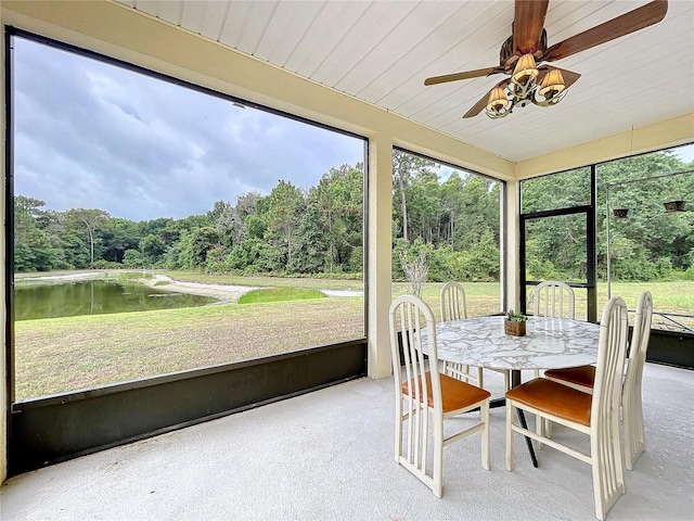 unfurnished sunroom featuring a water view and ceiling fan