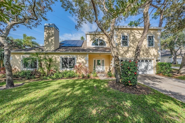 view of front of property with solar panels, a garage, and a front lawn