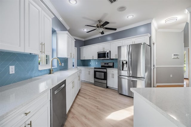 kitchen with white cabinetry, light stone countertops, stainless steel appliances, tasteful backsplash, and crown molding