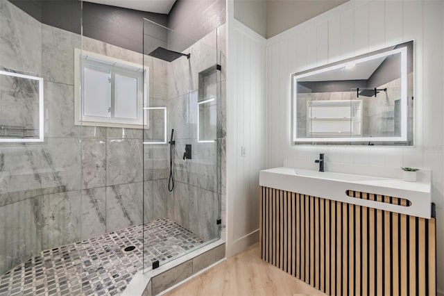 bathroom with hardwood / wood-style flooring and a shower with shower door