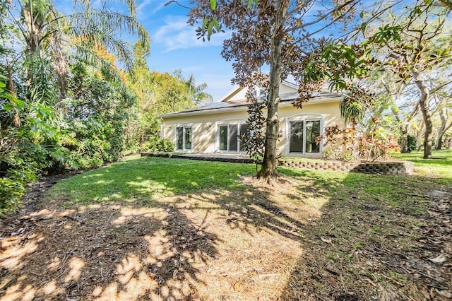 rear view of house featuring a yard