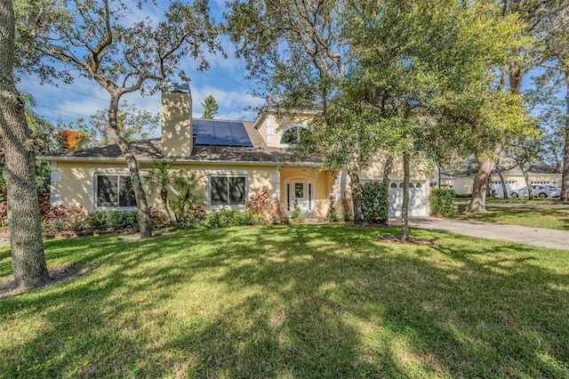 view of front facade featuring solar panels and a front lawn