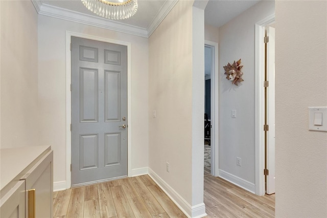 entryway featuring a chandelier, crown molding, and light hardwood / wood-style floors