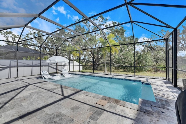 view of swimming pool featuring a lanai, pool water feature, and a patio