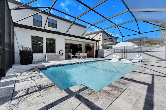 view of pool featuring pool water feature, a lanai, and a patio