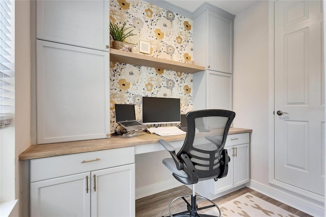 office space with light hardwood / wood-style flooring and built in desk