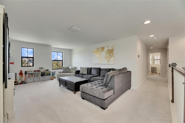 living room featuring a textured ceiling, light colored carpet, and radiator