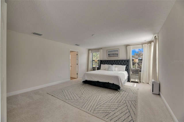 bedroom featuring a textured ceiling and light carpet