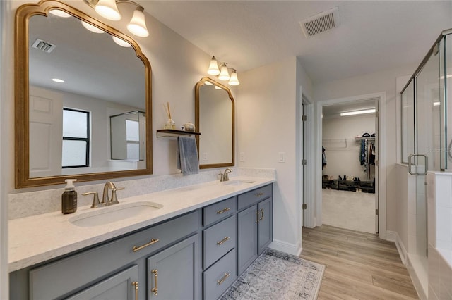 bathroom with vanity, an enclosed shower, and hardwood / wood-style flooring