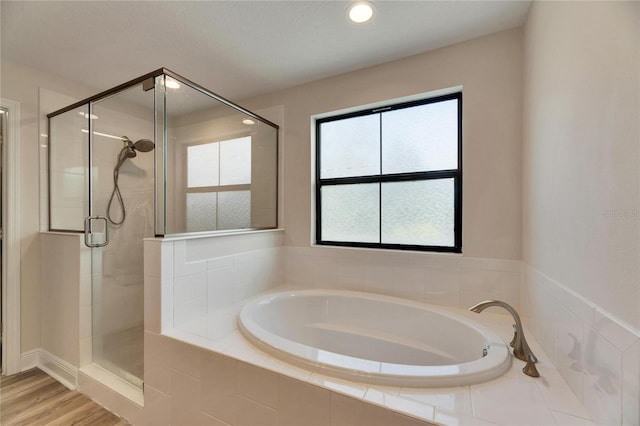 bathroom featuring hardwood / wood-style floors and plus walk in shower