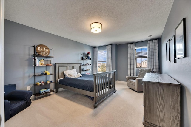 bedroom with light carpet and a textured ceiling