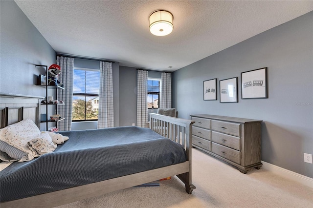 bedroom featuring light colored carpet and a textured ceiling