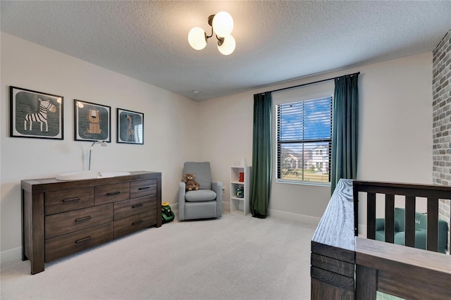 bedroom featuring light colored carpet and a textured ceiling