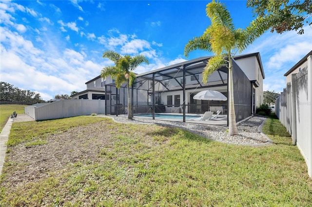 view of yard featuring a fenced in pool, glass enclosure, and a patio