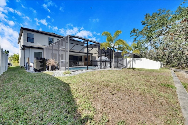 back of property with a lanai, a fenced in pool, and a yard