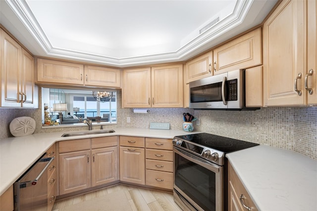 kitchen featuring decorative backsplash, light brown cabinets, stainless steel appliances, and sink