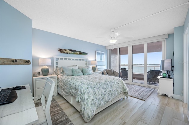 bedroom featuring access to exterior, ceiling fan, multiple windows, and light wood-type flooring