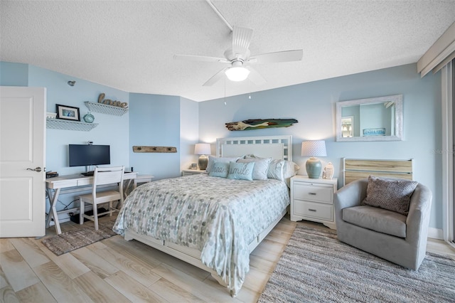 bedroom with a textured ceiling, light hardwood / wood-style flooring, and ceiling fan