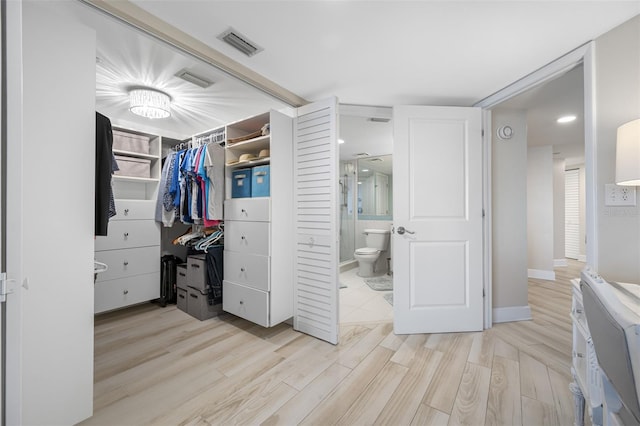 spacious closet with light hardwood / wood-style flooring