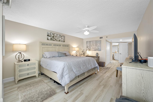 bedroom with ceiling fan, light hardwood / wood-style floors, and a textured ceiling