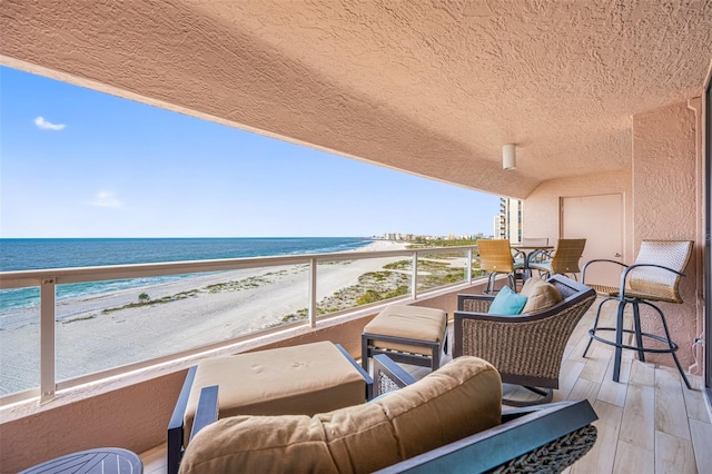 balcony featuring a water view and a view of the beach