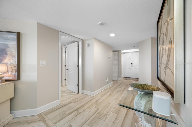 corridor featuring light hardwood / wood-style floors and a textured ceiling