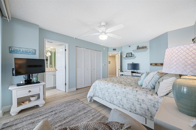 bedroom featuring connected bathroom, ceiling fan, light hardwood / wood-style flooring, a textured ceiling, and a closet