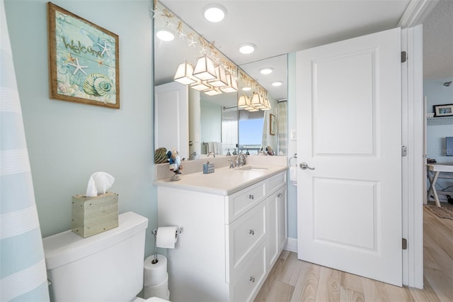 bathroom featuring vanity, hardwood / wood-style flooring, and toilet