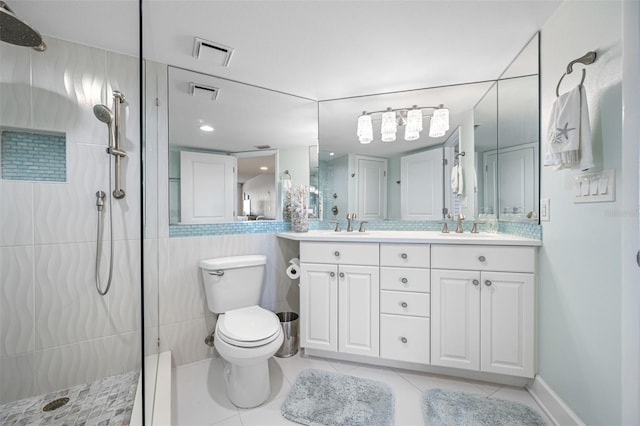 bathroom featuring tiled shower, vanity, toilet, and tile patterned flooring