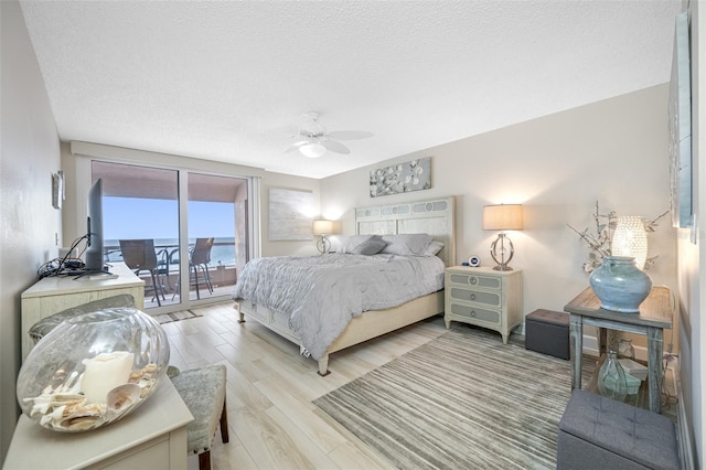 bedroom with ceiling fan, access to exterior, and a textured ceiling