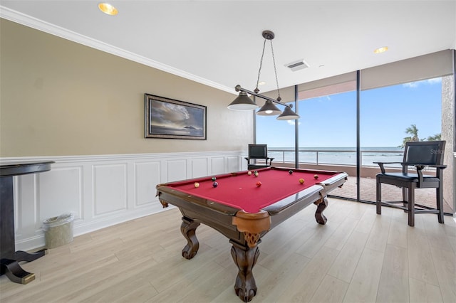 playroom featuring light wood-type flooring, a water view, ornamental molding, and pool table