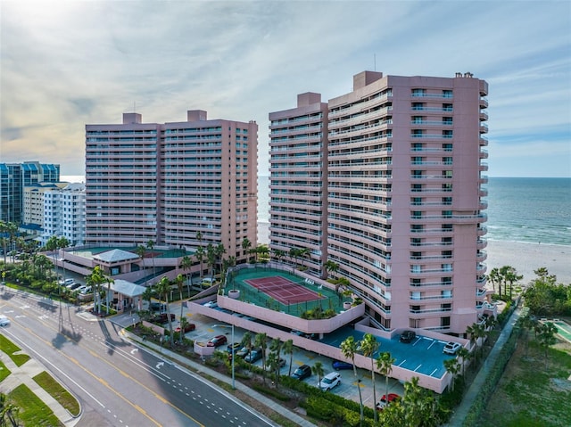 view of building exterior featuring a water view and a view of the beach