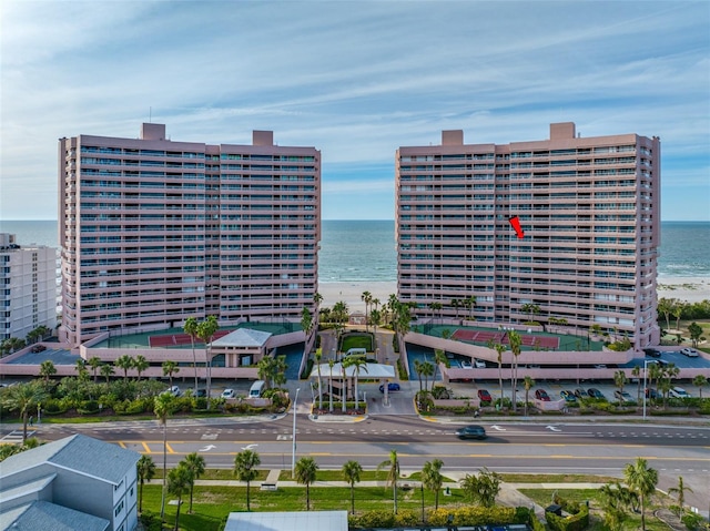 view of building exterior with a beach view and a water view