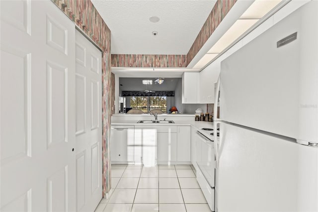 kitchen with sink, white refrigerator, dishwasher, white cabinets, and range