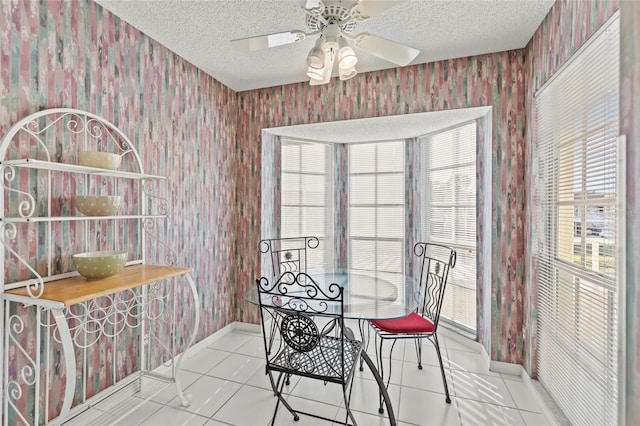 dining room with ceiling fan, light tile patterned floors, and a textured ceiling