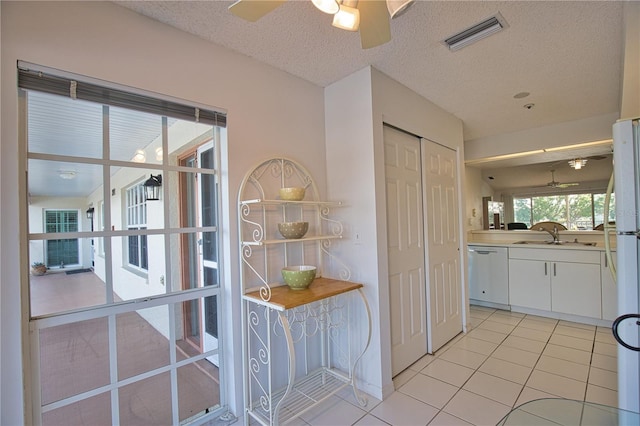 201 Silver Lake Dr Unit 204, Venice, FL 34292 - doorway with visible vents, ceiling fan, a textured ceiling, a sink, and light tile patterned floors