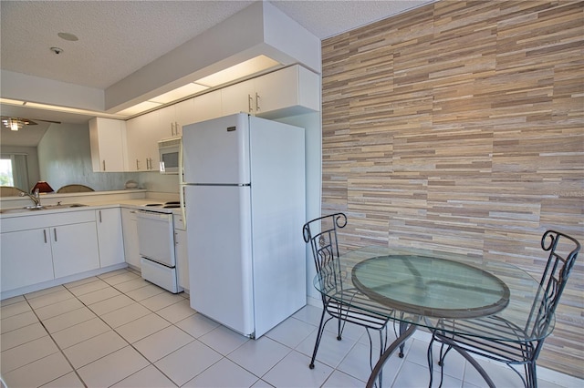 201 Silver Lake Dr Unit 204, Venice, FL 34292 - kitchen featuring white appliances, light countertops, a textured ceiling, a sink, and light tile patterned floors