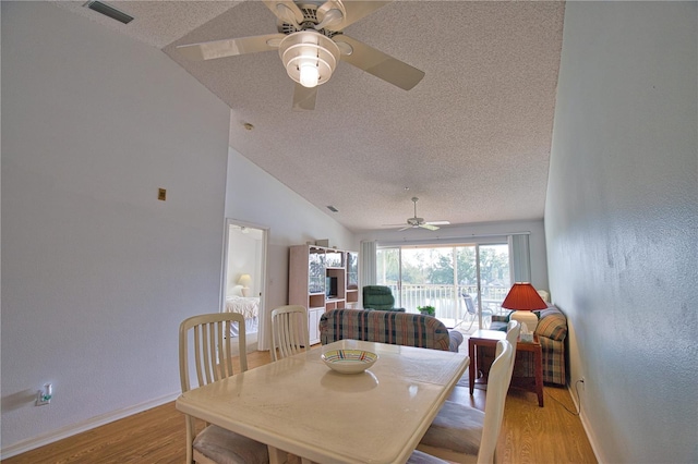 201 Silver Lake Dr Unit 204, Venice, FL 34292 - dining room with ceiling fan, light wood finished floors, a textured ceiling, baseboards, and lofted ceiling