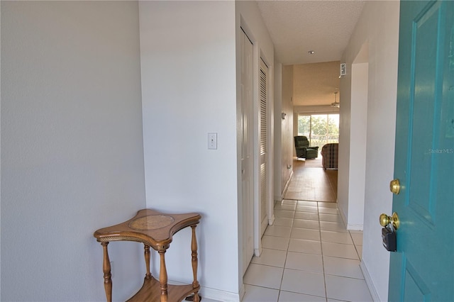 201 Silver Lake Dr Unit 204, Venice, FL 34292 - corridor featuring baseboards, a textured ceiling, and light tile patterned floors