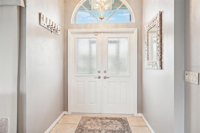 tiled foyer with an inviting chandelier