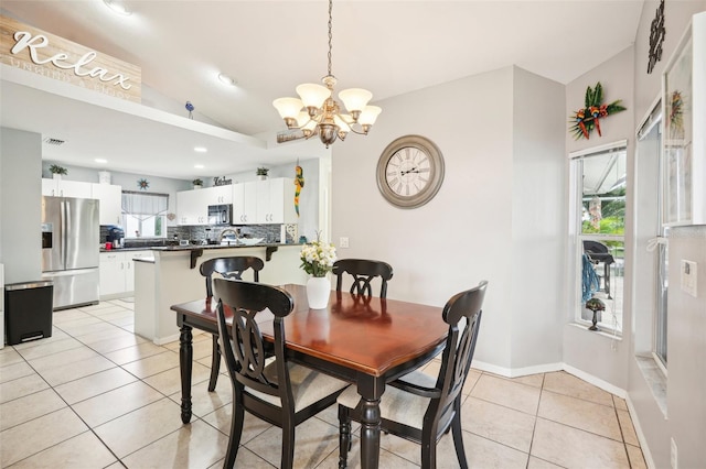 dining area featuring a notable chandelier, light tile patterned flooring, and lofted ceiling