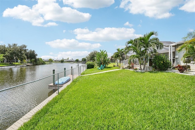 dock area featuring a lanai, a yard, and a water view