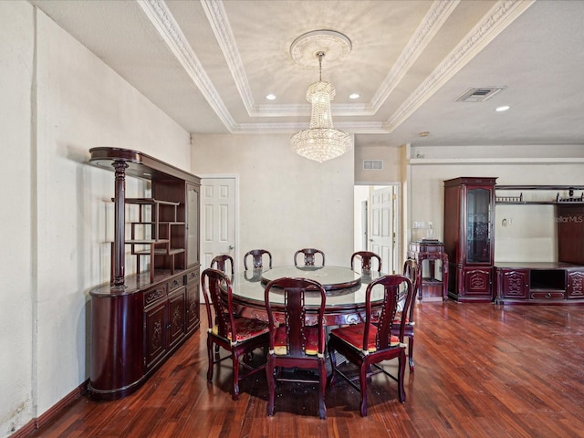 dining area featuring a notable chandelier, dark hardwood / wood-style flooring, a raised ceiling, and crown molding