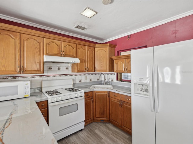 kitchen with white appliances, sink, light hardwood / wood-style flooring, decorative backsplash, and ornamental molding