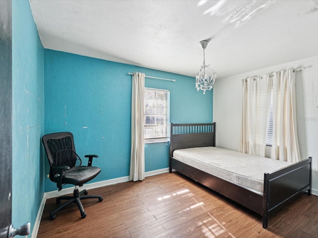 bedroom featuring hardwood / wood-style floors and a chandelier