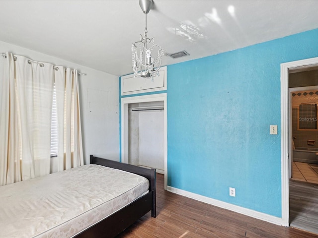 bedroom with dark hardwood / wood-style flooring and a chandelier