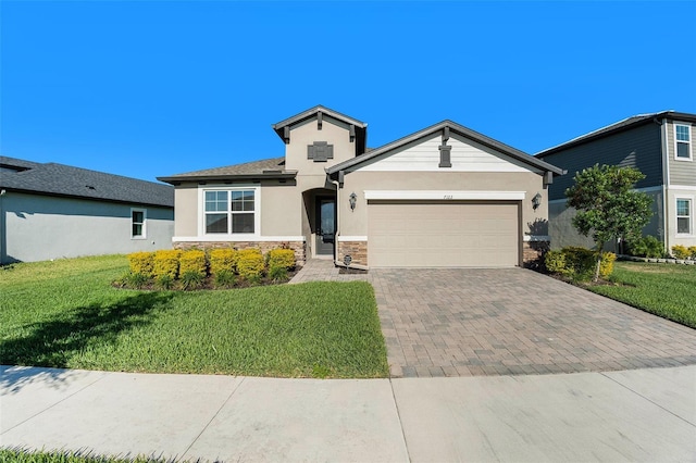 view of front of home with a garage, stone siding, decorative driveway, stucco siding, and a front lawn