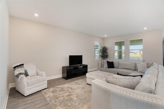 living area featuring light wood-type flooring, baseboards, and recessed lighting