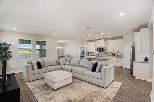 living room featuring visible vents, dark wood-style flooring, and recessed lighting